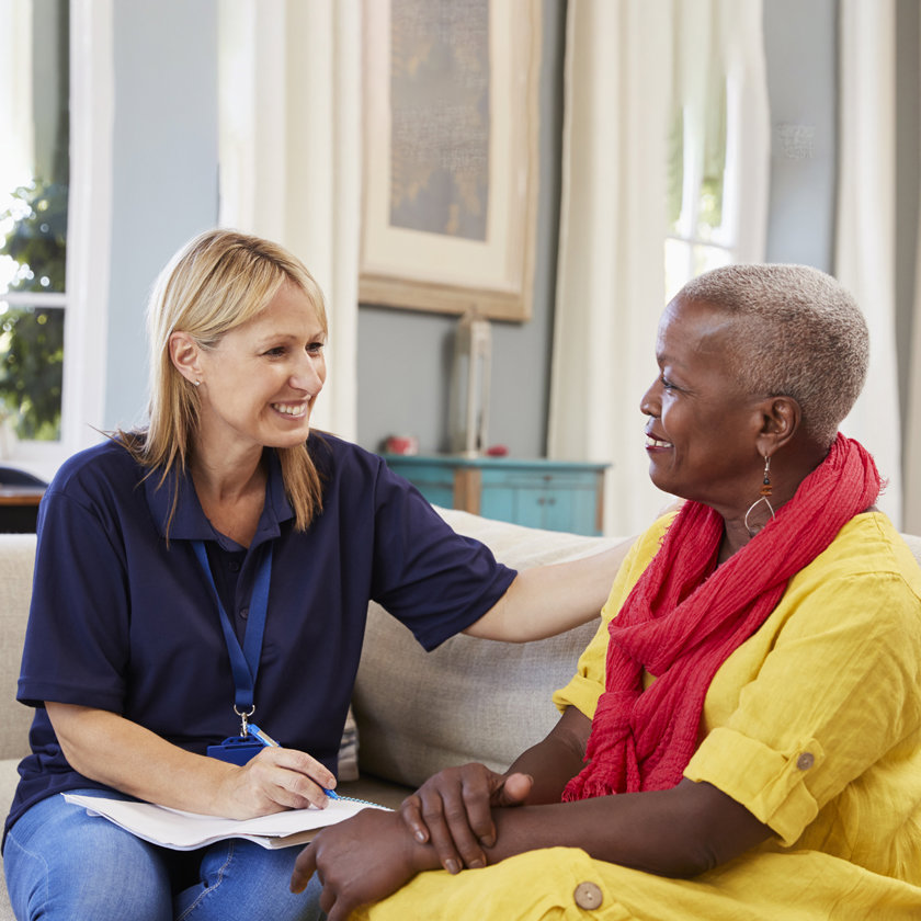 Care worker sitting on a couch with service user