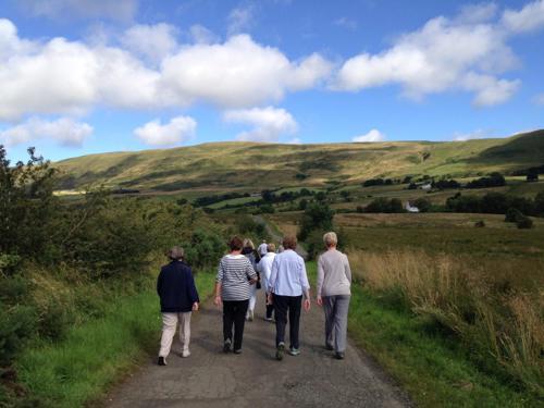 people walking along a path towards the campsies